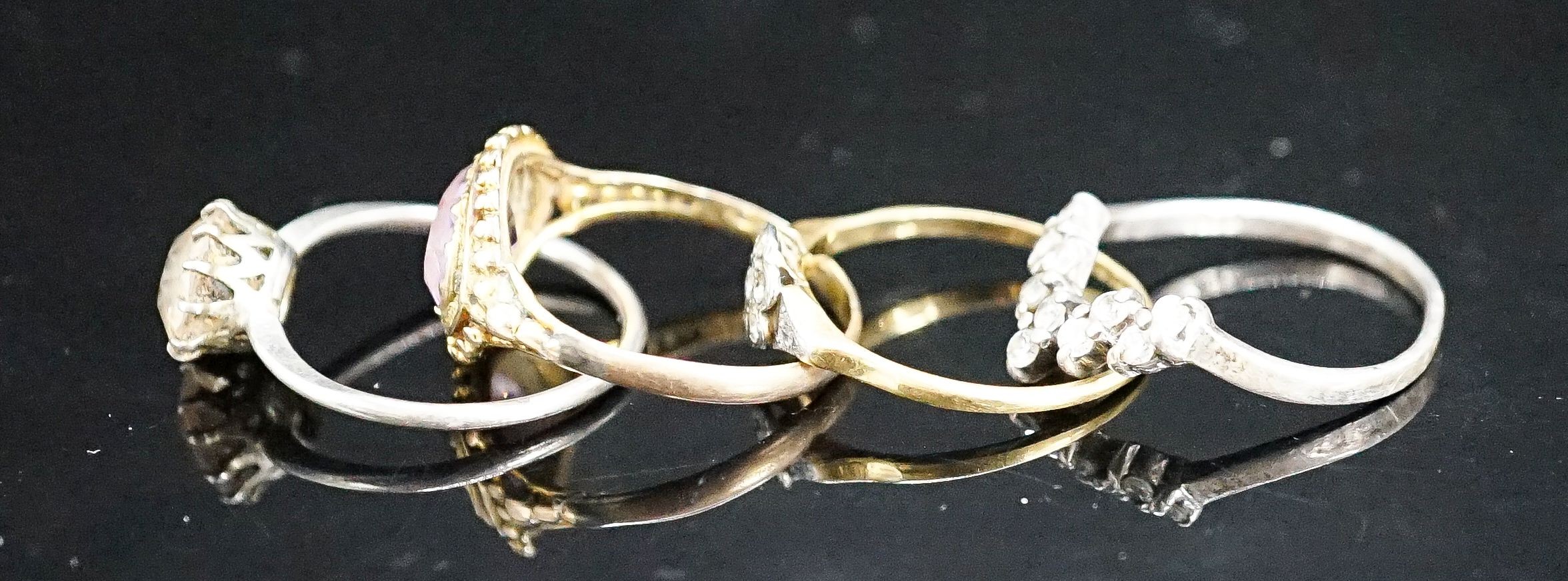A Victorian yellow metal and amethyst dress ring (shank a.f.), gross 2.6 grams, size P/Q, a small diamond set ring(a.f.), gross 1.8 grams and two paste rings.